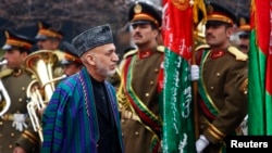 Presiden Afghanistan Hamid Karzai tiba di upacara pembukaan tahun keempat parlemen negara itu di Kabul (15/3). (Reuters/Mohammad Ismail)