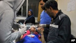 In this photo released by the Syrian official news agency SANA, a paramedic treats an injured woman wounded by Israeli missile strikes at a hospital in Damascus, Syria, Nov. 20, 2019.