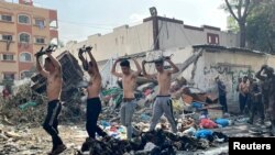 FILE - Men holding raised weapons are led out by Israeli soldiers near Kamal Adwan hospital, amid the ongoing conflict between Israel and Hamas, in Jabalia in the northern Gaza Strip, in this photo released December 14, 2023 by the Israel Defense Forces.