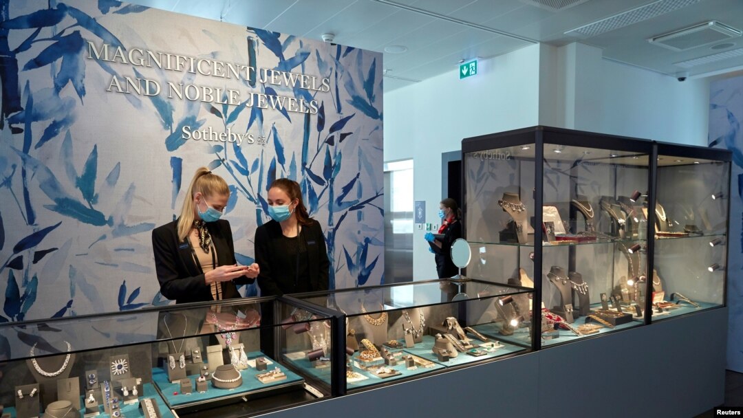 Personal de la joyería Sothesby's, usan tapabocas para atender a los clientes que realizarán una vista previa a las joyas antes de iniciar una subasta digital, en Ginebra, Suiza.