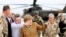 Germany's Chancellor Angela Merkel (C) points with German Minister of Defense Thomas de Maiziere as she makes a surprise visit to Bundeswehr base in Kunduz, Afghanistan, May 10, 2013.