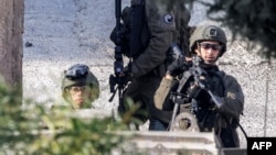 Israeli soldiers stand guard during an army raid in the Palestinian village of Qabatiyah in the north of the occupied West Bank, Jan. 10, 2025. 