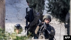 Israeli soldiers stand guard during an army raid in the Palestinian village of Qabatiyah, in the north of the occupied West Bank, Jan. 10, 2025. 