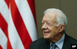 FILE - Former President Jimmy Carter smiles as he is awarded the Order of Manuel Amador Guerrero by Panamanian President Juan Carlos Varela during a ceremony at the Carter Center, January 14, 2016, in Atlanta.