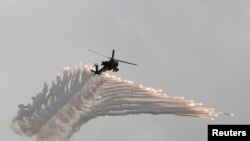 FILE - AH-64 Apache helicopter fires flares during Han Kuang military drill simulating the China's People's Liberation Army invading the island, at Ching Chuan Kang Air Base, in Taichung, Taiwan, June 7, 2018.