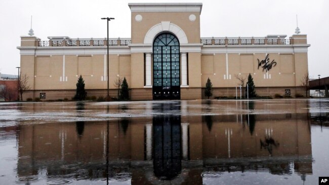 资料照片:在新罕布什尔州萨勒姆一家因新冠病毒疫情而关门的Lord & Taylor商店前,雨水渐落在空荡的停车场积水上。(2020年4月3日)