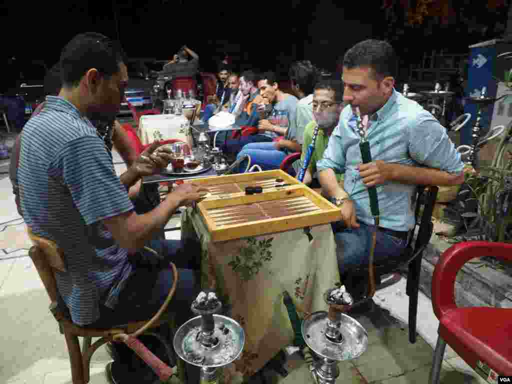 Warga Kairo bersantai dengan main backgammon dan mengisap shisha.&nbsp;(VOA/Hamada Elrasam)