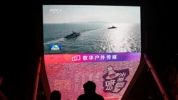 A giant screen shows news footage of military drills conducted in the Taiwan Strait and areas to the north, south and east of Taiwan, by the Eastern Theatre Command of the Chinese People's Liberation Army (PLA), in Beijing, China October 14, 2024. REUTERS/Tingshu Wang/File Photo