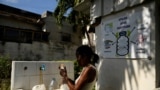 Seorang perempuan tampak mengisi botol yang ia bawa dengan air dari sebuah kelompok gereja yang menawarkan bantuan air kepada warga di Havana, Kuba, pada 12 September 2024. (Foto: Reuters/Norlys Perez)