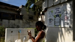 Seorang perempuan tampak mengisi botol yang ia bawa dengan air dari sebuah kelompok gereja yang menawarkan bantuan air kepada warga di Havana, Kuba, pada 12 September 2024. (Foto: Reuters/Norlys Perez)