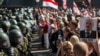 Belarusian security forces block a street during an opposition rally challenging official presidential elections results, in Minsk, Belarus, Aug. 30, 2020. The poster depicts President Alexander Lukashenko and the years he has been in power.