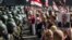 Belarusian security forces block a street during an opposition rally challenging official presidential elections results, in Minsk, Belarus, Aug. 30, 2020. The poster depicts President Alexander Lukashenko and the years he has been in power.