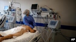 A health care worker tends to a COVID-19 patient at the Dr. Norberto Raul Piacentini hospital, in Lomas de Zamora, Argentina, April 23, 2021, amid the coronavirus pandemic.