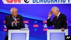 FILE - Democratic presidential candidate Sen. Bernie Sanders left speaks as former Vice President Joe Biden listens during a Democratic presidential primary debate, in Westerville, Ohio, Oct. 15, 2019.