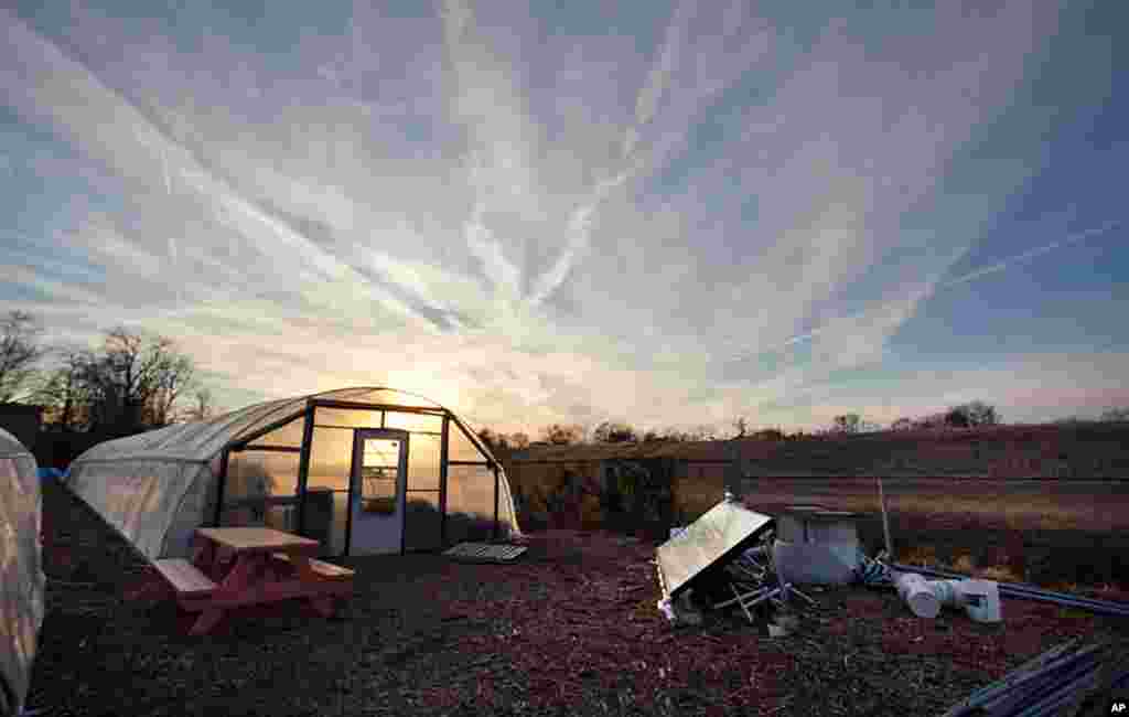 One of four greenhouses at the Edmonston farm. To the right is one of solar panels, which is how they power the farm. (Alison Klein/VOA)