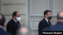 French President Emmanuel Macron, right, and Egyptian President Abdel-Fattah el-Sissi arrive for a joint news conference at the Elysee palace, in Paris, France, Dec. 7, 2020.