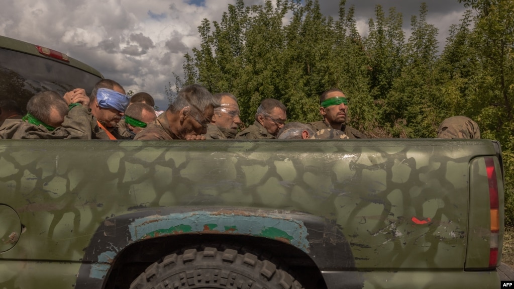 Un vehículo militar ucraniano avanza desde la dirección de la frontera con Rusia transportando a hombres con los ojos vendados y uniformes militares rusos, en la región de Sumy, el 13 de agosto de 2024, en medio de la invasión rusa de Ucrania.