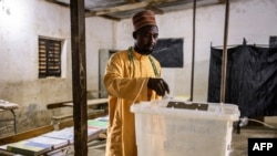 A voter casts his ballot at a voting station in the fishing village of Ndayane on Nov. 17, 2024.