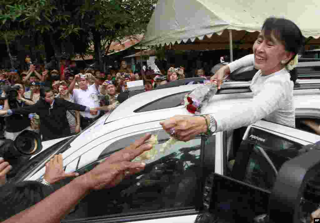 Aung San Suu Kyi is presented with flowers by cheering Karen refugees at Mae La refugee camp in Tha Song Yang district, Tak province, northern Thailand, June 2, 2012. 