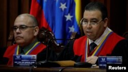 Juan Mendoza, right, Venezuela's Supreme Court second vice president and president of the Constitutional Chamber, seated next to Arcadio Delgado, a member of the of the Constitutional Chamber, gives a news conference in Caracas, Venezuela, July 21, 2017. The Supreme Court ruled that the National Assembly's appointment of a new slate of judges to the high court was unconstitutional. 