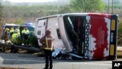 Emergency services personnel stand at the scene of a bus accident crashed on the AP7 highway that links Spain with France along the Mediterranean coast near Freginals halfway between Valencia and Barcelona on March 20, 2016.