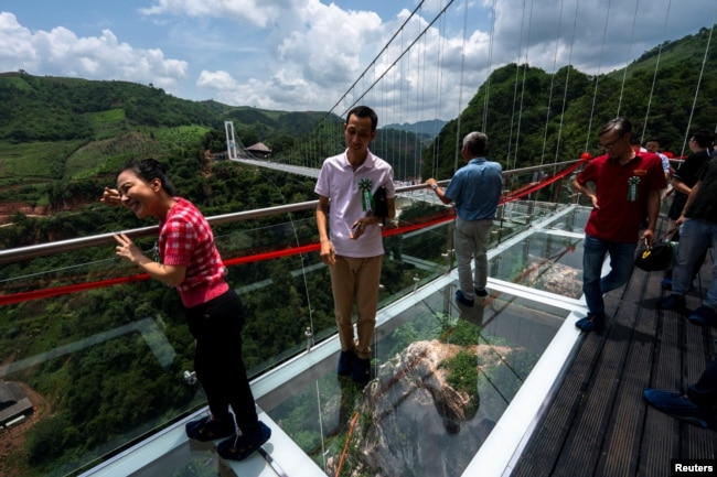 People walk on the Bach Long glass bridge during the opening ceremony in the Son La area, Vietnam, on May 28, 2022. (REUTERS/Athit Perawongmetha)
