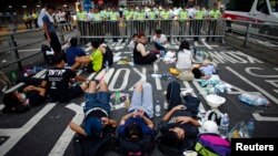 Demonstran memblokir jalan dekat kantor-kantor pemerintahan di Hong Kong (30/9).