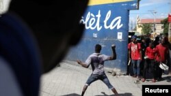 Yon manifestan kap tire yon wòch pandan mach pou mande depa Prezidan Jovenel Moïse sou pouvwa a ak yon ankèk sou dilapidasyon Fon Petro Carive a sou Gouvènman avan yo. Foto: . REUTERS/Andres Martinez Casa