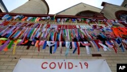 Ribbons hang in remembrance of victims of the coronavirus pandemic outside the Grant African Methodist Episcopal Church, Tuesday, May 19, 2020, in Boston. (AP Photo/Steven Senne)