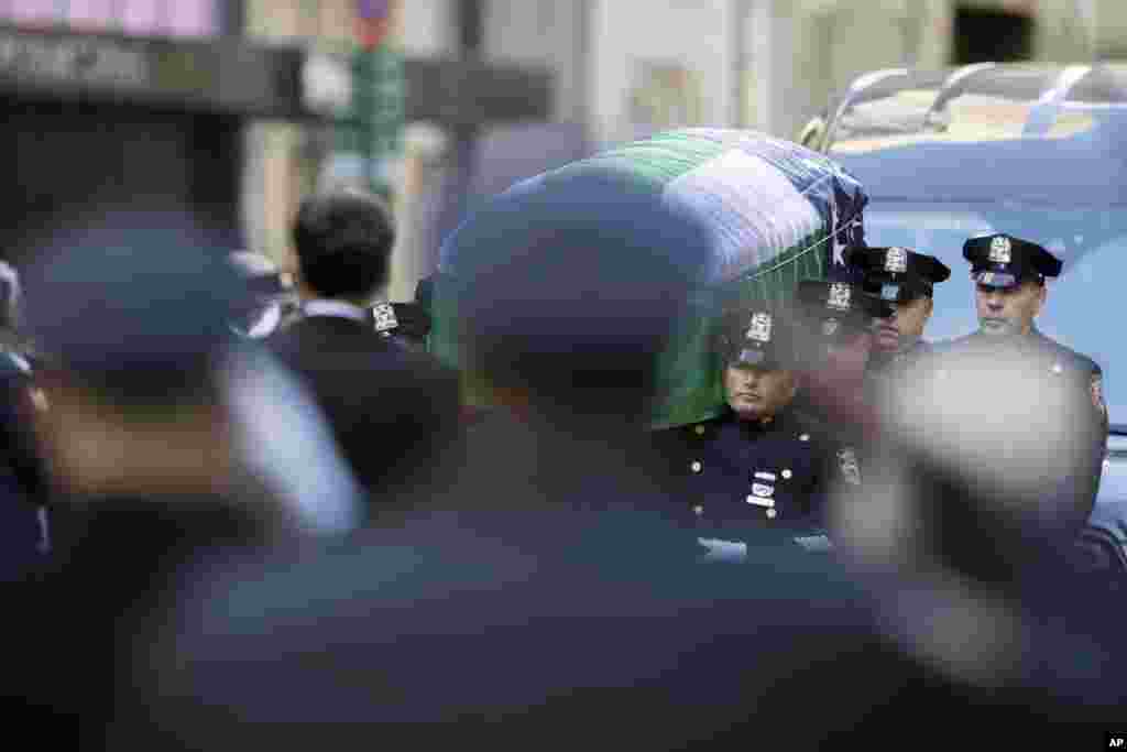 Police officers salute as pallbearers carry the casket of New York City police officer Steven McDonald after his funeral service at St. Patrick&#39;s Cathedral in New York. McDonald died on Tuesday, 30 years after a robbery suspect shot him in Central Park. The officer publicly forgave his assailant and became an international voice for peace.