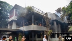 People gather at the Bangabandhu Memorial Museum of Sheikh Mujibur Rahman, Bangladesh's founding father and parent of the country's ousted Prime Minister Sheikh Hasina, after it was torched by anti-government protestors in Dhaka on Aug. 6, 2024.