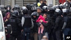 Des habitants évacués pendant l'assaut à Saint-Denis, en France, 18 novembre 2015. (AP Photo/Peter Dejong)