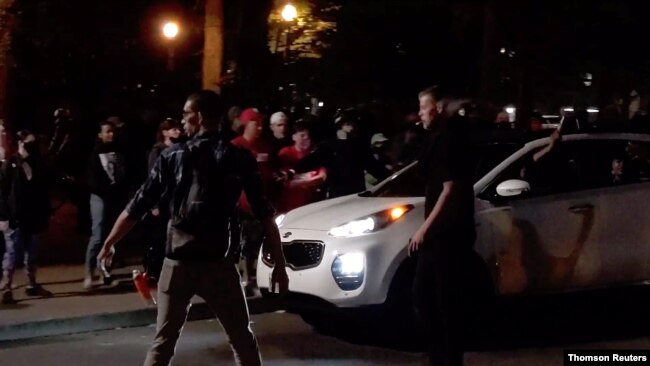 A driver fires a gun in the air near demonstrators during a Black Lives Matter protest in Portland, Oregon