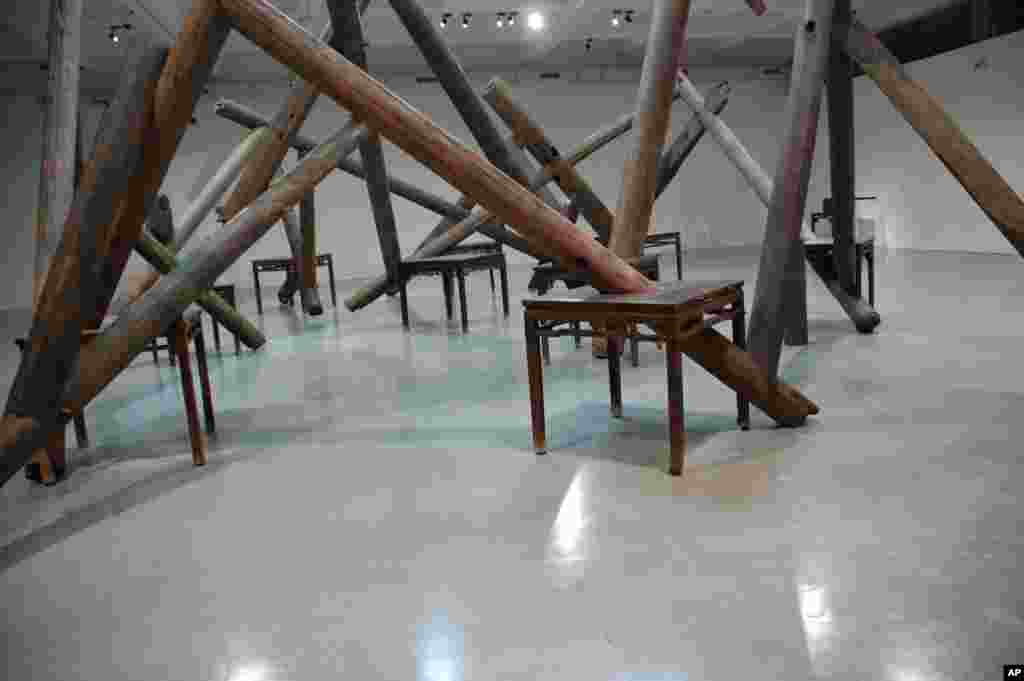 用清朝庙宇的铁力木桌子和梁柱建构的装置作品“through”，可以带来多种联想，例如“人字的结构是互相支撑。”