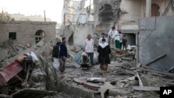 FILE - People inspect the damage of houses destroyed by Saudi-led airstrikes in Sanaa, Yemen, Jun. 9, 2017. 
