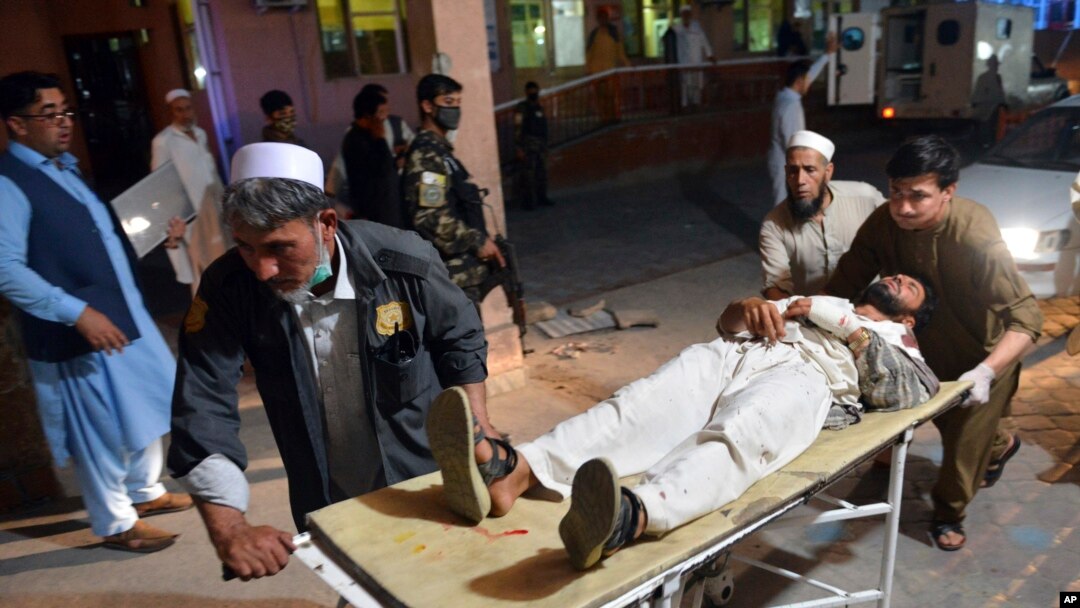 FILE - A wounded man is brought by stretcher into a hospital in Jalalabad city, capital of Nangarhar province, east of Kabul, June 16, 2018. 