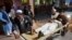 FILE - A wounded man is brought by stretcher into a hospital in Jalalabad city, capital of Nangarhar province, east of Kabul, June 16, 2018. 