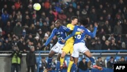 Le défenseur brésilien du Paris Saint-Germain Marquinhos, au centre, saute entre le défenseur français Ernest Seka, à gauche, et le défenseur burkinabé de Strasbourg Bakary Kone, à droite, lors du match de football L1 entre Strasbourg (RCSA) et Paris Sain