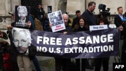 Người ủng hộ nhà sáng lập WikiLeaks Julian Assange cầm biểu ngữ bên ngoài Tòa Công lý Hoàng gia ở Trung tâm London hôm 26/3.
