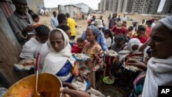 FILE - Displaced Tigrayans queue to receive food donated at a reception center for the internally displaced, in Mekele, in the Tigray region of northern Ethiopia, May 9, 2021. 