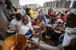 FILE - Displaced Tigrayans queue to receive food donated by local residents at a reception center for the internally displaced in Mekele, in the Tigray region of northern Ethiopia, May 9, 2021.