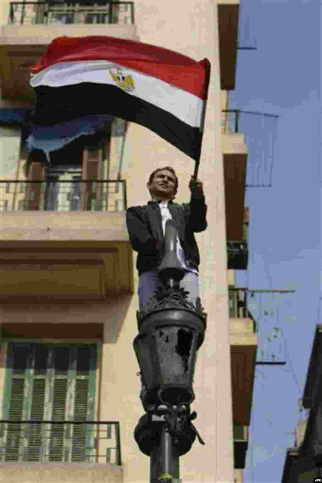 An anti-government protester waves his country flag, in Tahrir Square, in Cairo, Egypt, Friday, Feb. 11, 2011. Egypt exploded with joy, tears, and relief after pro-democracy protesters brought down President Hosni Mubarak with a momentous march on his pal