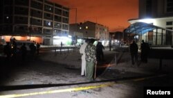 Policemen inspect the secured section at the scene of the blast in Eastleigh suburb of Kenya's capital Nairobi, December 7, 2012.