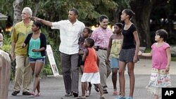 President Barack Obama walks with his daughters Sasha Obama, sixth from right, Malia Obama, second from right, and other family and friends through Honolulu Zoo, 3 Jan. 2011.