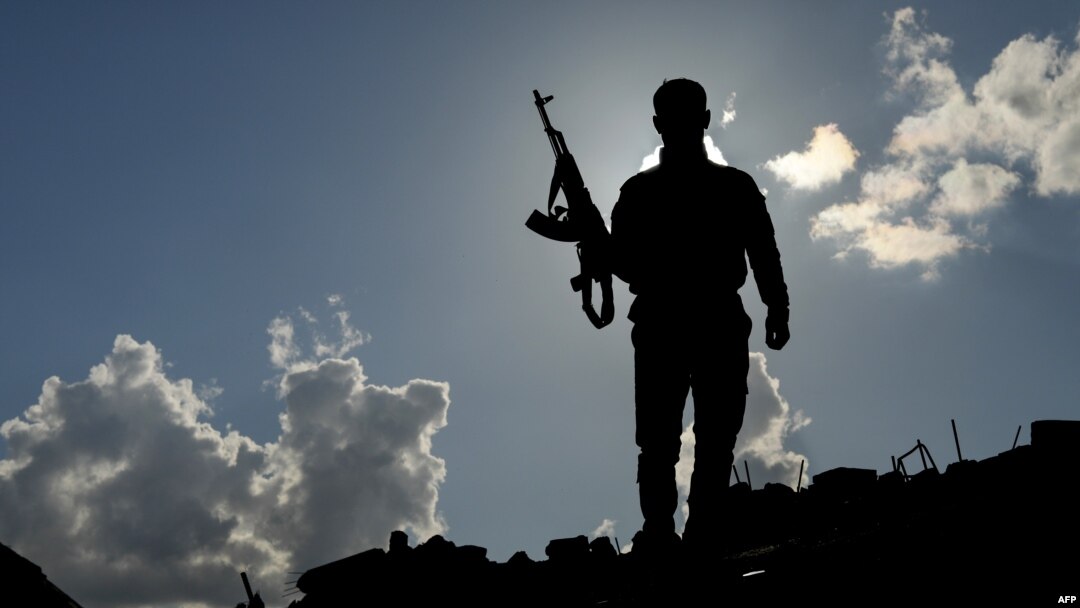 A fighter of the U.S.-backed Syrian Democratic Forces stands guard in the front-line Syrian village of Baghuz, Feb. 18, 2018. SDF forces have been fighting against the last shred of the Islamic State group's caliphate in eastern Syria.