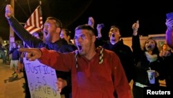 Garrett Plath (L) and Kyle Senechal, both of North Attleborough, protest outside the Dyer-Lake Funeral Home, where they believed deceased Boston Marathon bombing suspect Tamerlan Tsarnaev's body was being held, May 2, 2013. 