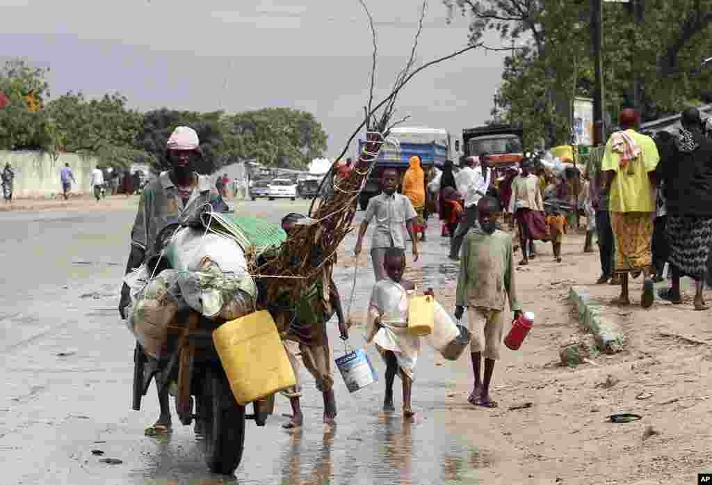 Displaced people flee Badbado settlement after two groups of Somalia government soldiers clashed inside the camp in the capital Mogadishu, August 5, 2011. (Reuters)