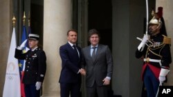 El presidente francés, Emmanuel Macron (izq.), da la bienvenida al presidente argentino, Javier Milei, en el Palacio del Elíseo antes de la ceremonia de apertura de los Juegos Olímpicos de Verano el viernes 26 de julio de 2024, en París, Francia.