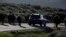FILE - A car is stopped by a herd of bison crossing the highway in Yellowstone National Park, Wyoming, June 8, 2013. 