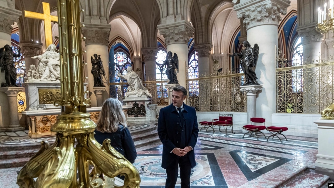French President Emmanuel Macron speaks with an art restorer as he visits the restored interiors of the Notre-Dame de Paris cathedral, Nov. 29, 2024 in Paris.